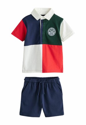 Polo de manga corta con bloques de color en rojo, azul marino, verde y blanco, combinado con pantalones cortos azul marino con cordón.