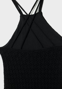Haut halter noir avec un design en crochet texturé en bas, des bretelles croisées à l'arrière et une section supérieure lisse.