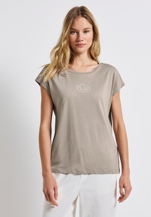 Ljust beige bomull t-shirt med korta ärmar, rund halsringning och subtilt tryckt texten "Quite Plain" i en ljusare nyans på framsidan.
