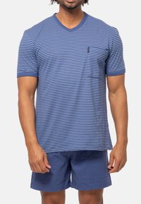 Blårandig kortärmad skjorta med V-ringning och ficka, tillsammans med enfärgade blå shorts, båda gjorda av mjuk bomullstyg.