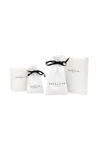 Trois articles d'emballage : deux sachets en tissu blanc avec des liens noirs et une boîte blanche, tous présentant l'étiquette "SATELLITE PARIS-FRANCE."