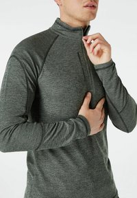 Grau zip-up Langarmoberteil aus strukturiertem Stoff mit Flachnaht. Verfügt über einen Viertelreißverschluss und schmale Ärmel.