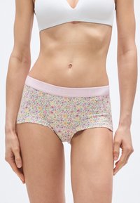 Gėlėto rašto šortai iš minkštos medžiagos su rožine elastine juosta, pažymėta „PIECES“. Turi šviesų foną su spalvingais gėlių raštais.
