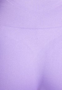 Lila Leggings mit gerippter Struktur an der Taille, glattem Stoff und einer figurbetonten Passform, die zu einer schlanken Silhouette zuläuft.