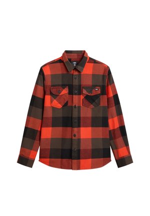 Camisa de franela a cuadros rojos y negros con mangas largas, cierre frontal de botones, dos bolsillos en el pecho y detalles contrastantes en marrón.