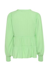 Vihreä pitkähihaine paita, jossa on peplum-malli ja kerätty hihansuut. Pehmeä pinta, pyöreä pääntie ja joustavat hihansuut.