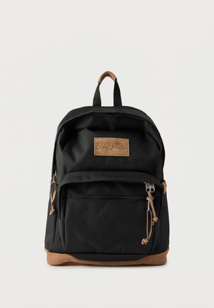 Svart Jansport-ryggsekk med brune semskede detaljer, frontlomme med glidelås og bærehåndtak på toppen mot en ensfarget hvit bakgrunn.