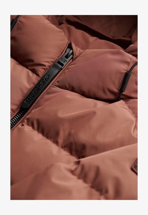 Brown insulated jacket with a black zipper. The fabric is smooth and puffy, featuring quilted sections for warmth and texture.