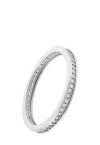 Bague en argent avec un extérieur lisse, une rangée de petites pierres claires le long d'un bord, une finition polie et une forme arrondie.