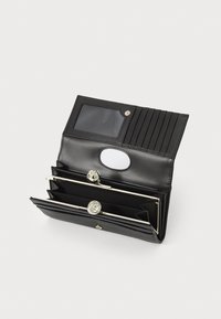 Carteira de pele preta com múltiplos slots para cartões, uma janela clara para identificação e ferragens em tom prateado. Apresenta compartimentos em estilo acordeão para organização.