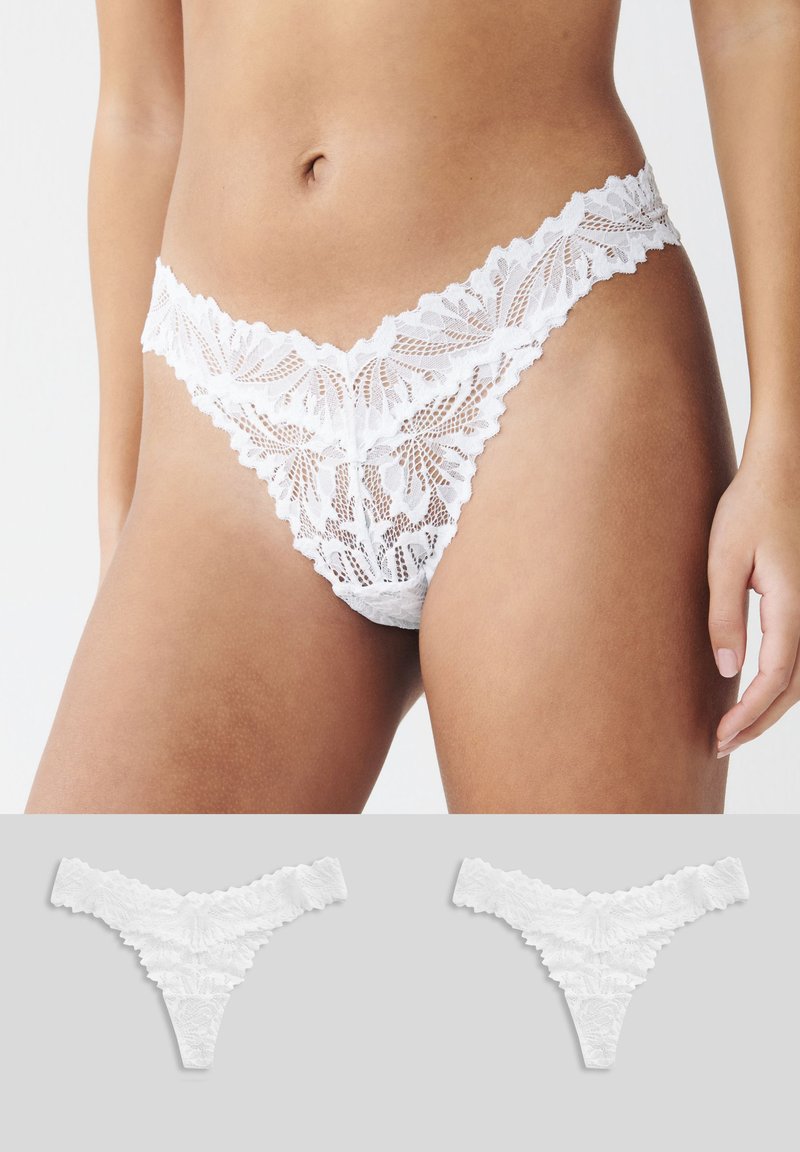 String en dentelle blanche avec motif floral, bords festonnés et texture transparente. Deux paires identiques supplémentaires affichées en dessous.