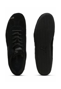 Sorte nubuck sneakers med snørebånd, struktureret gummisål og Puma-logo på siden og på tungen. Glat indvendig foring.