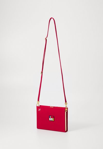 Borsa a tracolla rettangolare rossa con lunga tracolla regolabile, hardware dorato e un piccolo design geometrico bicolore sulla parte anteriore.