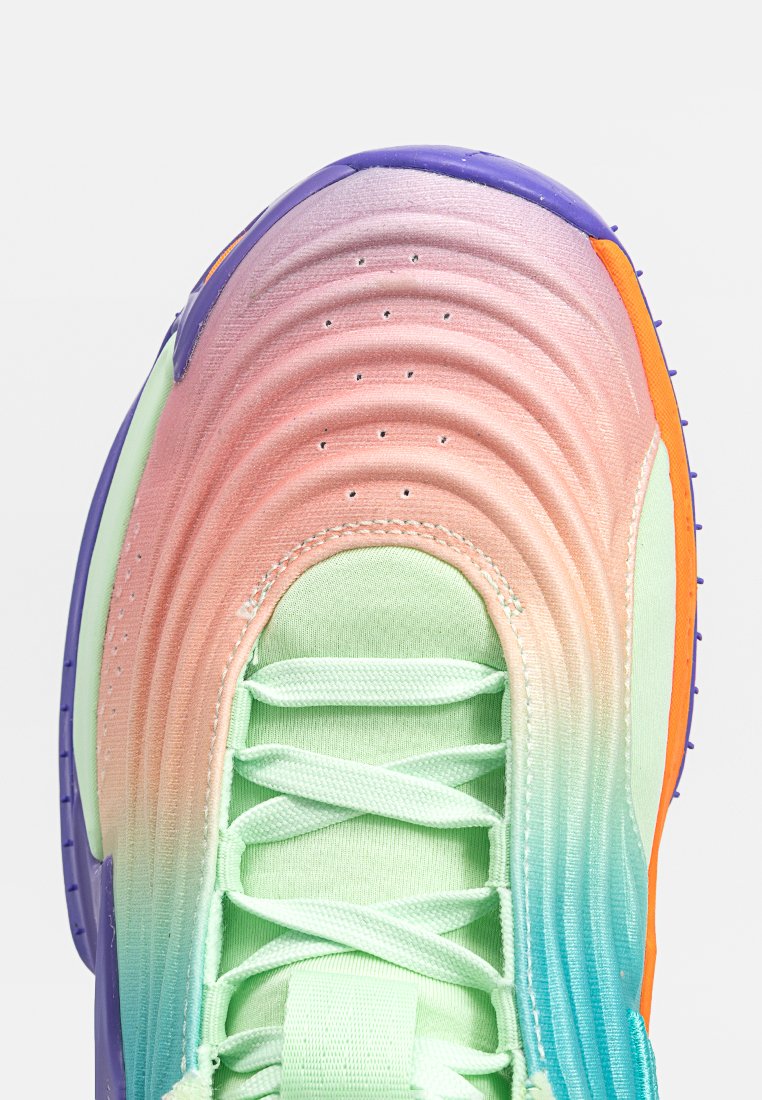 Bout de sneaker avec des dégradés de couleurs allant du rose au vert puis au bleu, lacets vert clair, accents violets et orange, et trous de ventilation perforés.