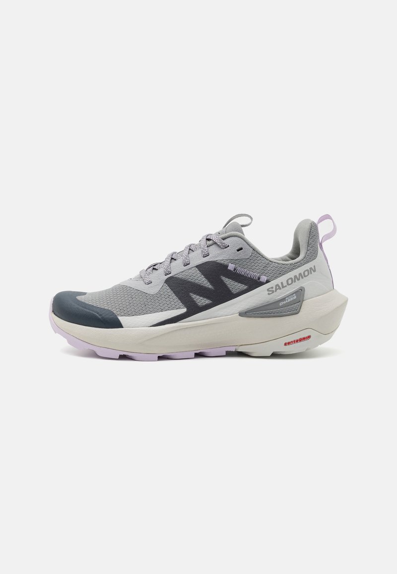 Chaussure de sport légère grise et violette avec tige en mesh respirant, lacets à motifs et semelle épaisse et rembourrée, arborant le logo Salomon sur le côté.