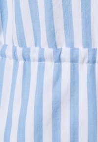 Tessuto di cotone a righe blu e bianche; presenta una superficie testurizzata con delicate pieghe lungo la cucitura e dettagli di cucitura pulita.