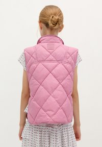 Roze gewatteerde mouwloze vest met hoge kraag en logo patch op de achterkant, ontworpen met een gladde textuur en ruitvormig patroon.