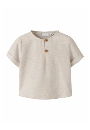 Maglietta beige per bambini con maniche corte, scollo rotondo, due bottoni di legno sulla patta frontale e polsini delle maniche arrotolati.