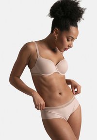Soutien-gorge rembourré beige avec un tissu texturé et des détails en dentelle, associé à un slip taille basse assorti arborant un motif subtil et une taille en dentelle.