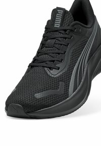 Zapatilla deportiva negra con parte superior de malla transpirable, acentos sintéticos texturizados, cordones y marca Puma. Diseño ligero con una suela acolchada.