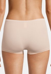 Beżowe majtki typu boyshorts wykonane z miękkiego, gładkiego materiału, z minimalną liczbą szwów, z średnim stanem i bezszwowym designem dla komfortu.