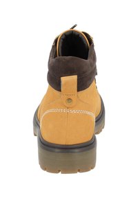 Botines de cuero y ante en amarillo y marrón. Presentan costuras, un zipper metálico y suela de goma. La vista trasera muestra una lengüeta de agarre.