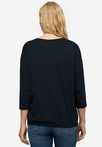 Černý, lehký, dlouhý rukáv top s kulatým výstřihem a volným střihem, s tříčtvrtečními rukávy a zaobleným spodním lemem.