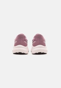 Fioletowe buty sportowe z teksturowaną cholewką, wyściełanym kołnierzem i białą środkową podeszwą. Czarna gumowa podeszwa zewnętrzna z wzorami zapewniającymi przyczepność i stabilność.