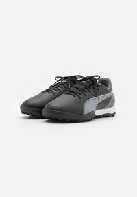 Black athletic shoes with a sleek design, featuring a smooth leather upper, textured rubber sole, and a striped white accent.