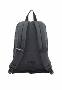 Mochila acolchada negra con dos correas ajustables y un asa en la parte superior. Presenta una etiqueta de PET reciclado y un pequeño logo en el lateral.