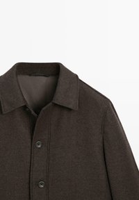 Cappotto marrone a spina di pesce con colletto a risvolto e tre bottoni. Tessuto testurizzato, fodera liscia e design minimalista.