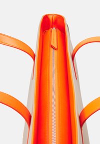 Beige tote-väska med orange inredning, som har dragkedjestängning och orange detaljer. Slät yta; två handtag för bärande.