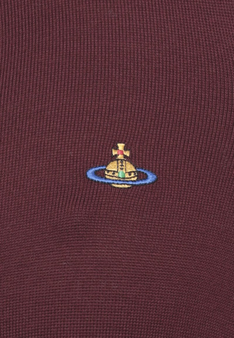 Orbe giallo con una croce in cima, circondato da un anello blu, ricamato su un tessuto rigato bordeaux.