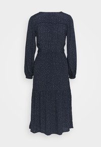 Robe midi bleu marine à manches longues avec motif de points blancs dispersés, taille cintrée et jupe à volants froncée, vue de dos.