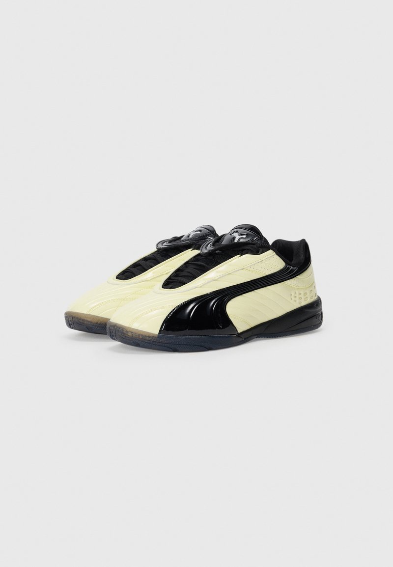 Baskets de sport jaunes et noires au design épuré, avec une tige texturée et des accents lisses et brillants. Semelle en caoutchouc pour une meilleure adhérence.