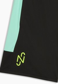 Shorts de sport noirs et vert menthe avec un logo stylisé "N" jaune néon près de l'ourlet sur la partie noire.