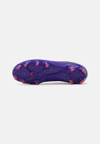 Football cleat with a textured purple sole, featuring prominent orange studs and a streamlined design for traction on grass surfaces.