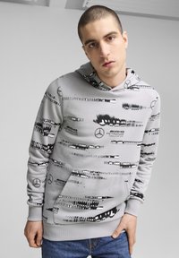 Grey hoodie with black abstract patterns, featuring a front pocket and a drawstring hood. Made from soft fabric with a comfortable fit.