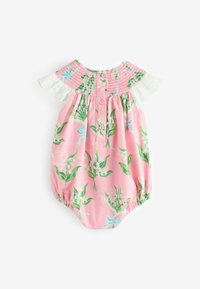 Růžový bavlněný overálek s květinovými vzory v zelené a modré barvě, s nařaseným živůtkem, bílou krajkovou aplikací a knoflíkovým zapínáním na zádech.