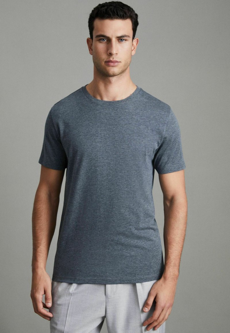 Tricou pentru bărbați cu mânecă scurtă de culoare gri închis, realizat dintr-un material moale. Dispune de un gât rotund și o croială lejeră, cu o textură netedă.