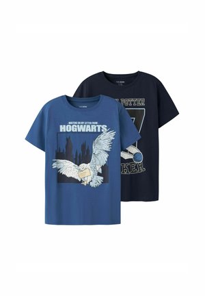 Twee T-shirts met korte mouwen: één blauwe met een witte uil en een Hogwarts-graphic, en één marineblauwe met de tekst "Harry Potter" en een sportembleem ontwerp.