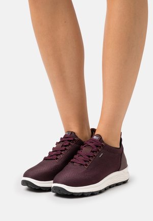 Burgundowe buty sportowe wykonane z teksturowanej siateczki, z sznurówkami, wyprofilowanym kołnierzem oraz białymi podeszwami z falistym wzorem.