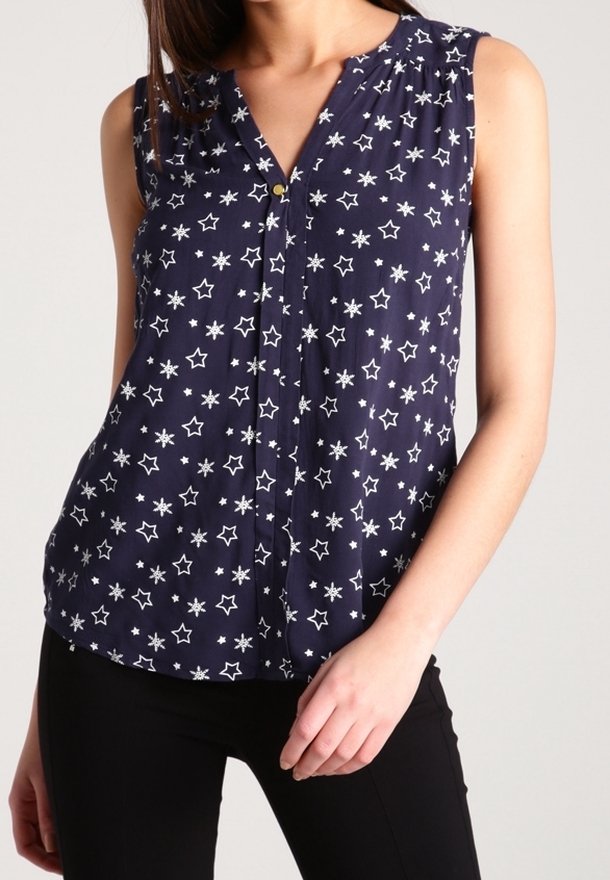 Laivaliike ilman hihoja, jossa on V-aukko, nappikiinnitys ja valkoisia tähtiä. Kevyt, hengittävä kangas ja rento malli.