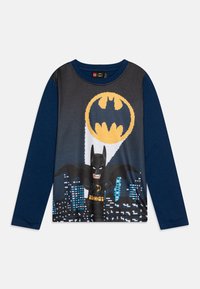 Long-sleeve t-shirt featuring a Batman graphic on a dark background, with blue sleeves, a round neckline, and a soft cotton material.