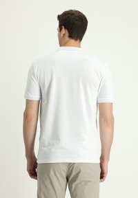 Polo shirt bianco a maniche corte con colletto. Tessuto morbido, design minimalista e rifinitura a contrasto sulle maniche. Vista posteriore mostrata.