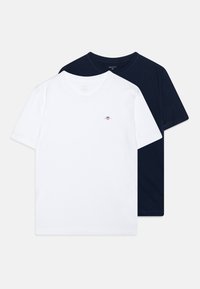Deux t-shirts en coton : un blanc avec un petit logo et un bleu marine. Manches courtes, design à col rond, texture de tissu lisse.