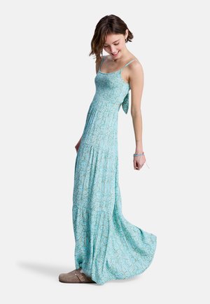 Μάξι φόρεμα σε τιρκουάζ ύφασμα με λουλουδάτο μοτίβο, με λεπτές τιράντες και κορδέλα στη πλάτη. Ροή σιλουέτας και ελαφριά υφή.
