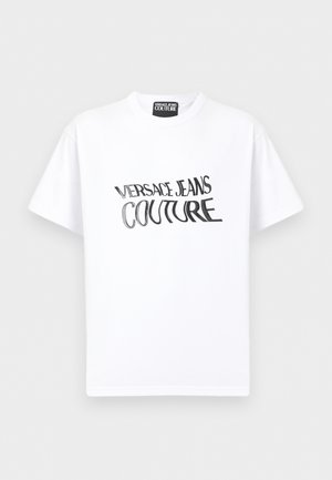 Hvit kortermet t-skjorte med svart "VERSACE JEANS COUTURE"-tekst som er forvrengt på forsiden, og Versace Jeans Couture-merkelapp ved kragen.