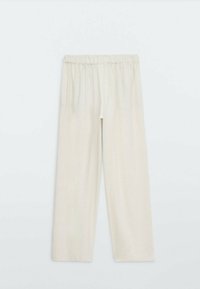 Pantalon beige clair à jambes larges avec tissu texturé et taille élastique. Design décontracté, longueur complète avec une coupe ample.