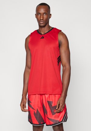 Camisola atlética vermelha com detalhes em preto, combinada com calções vermelhos com um padrão geométrico abstrato em preto, feitos de material leve.